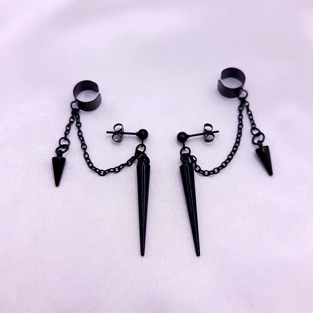 Black spike earrings with chain on a white background