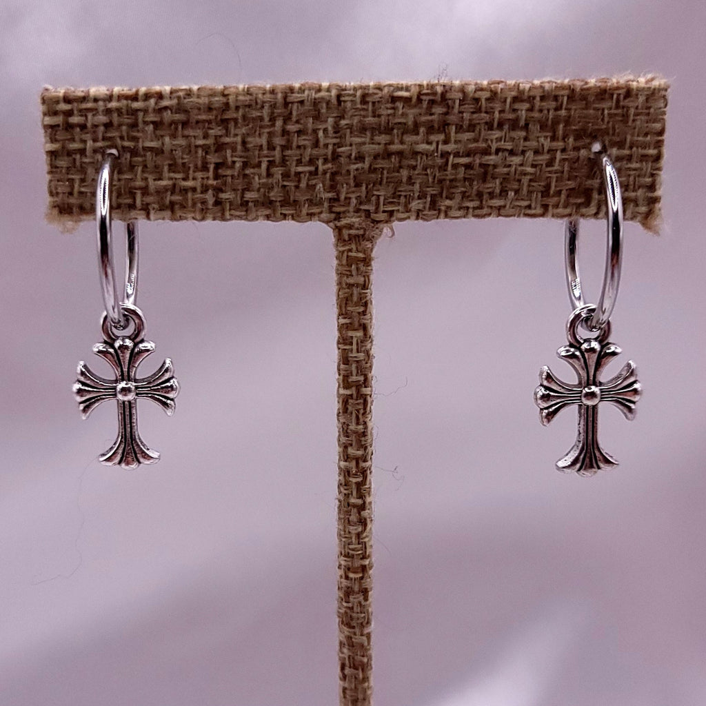 Silver ring with a cross design on a fabric background